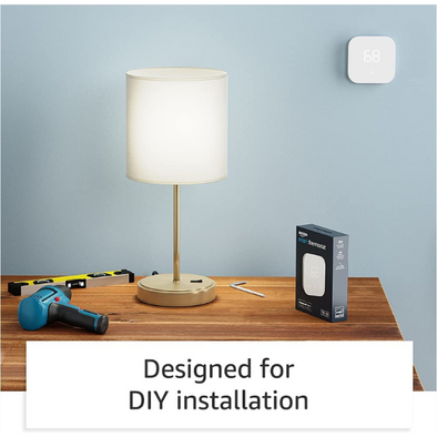 A desk with a drill, level, and hex key sitting next to an Amazon smart thermostat box. The thermostat is on the wall and a text box reads "designed for DIY installation"