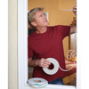 A man installs white weather strip in a window frame.