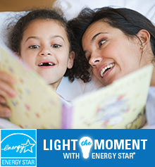 A closeup image of a mom and daughter reading a book together. The ENERGY STAR logo is shown and text reads “Light the Moment with ENERGY STAR.”