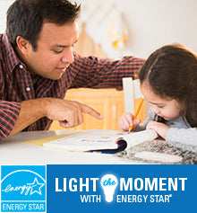 A dad helps his daughter with her homework. The ENERGY STAR logo is shown and text reads “Light the Moment with ENERGY STAR.”