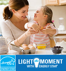 A mom and daughter are baking together. The ENERGY STAR logo is shown and text reads “Light the Moment with ENERGY STAR.”